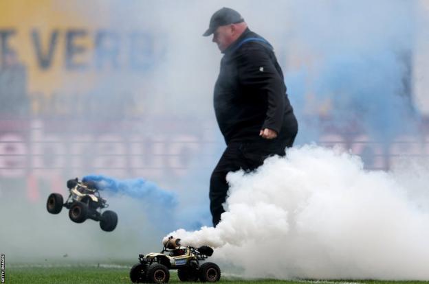 Bundesliga 2: Remote control cars with smoke bombs halt Hansa Rostock v Hamburg Bundesliga 2: Remote control cars with smoke bombs halt Hansa Rostock v Hamburg