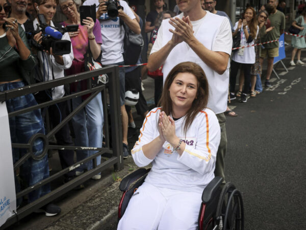 A Lebanese photojournalist, wounded in Israeli strike, carries Olympic torch to honor journalists