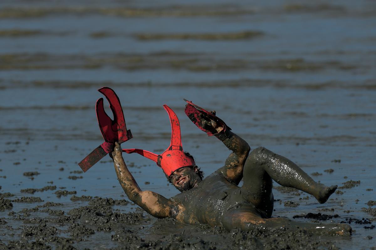 Mud-covered Carnival revelers are a strange sight in sleepy Brazilian town